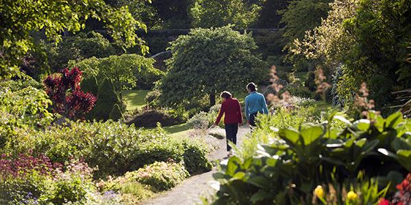 A couple walking through the gardens of Wallington estate