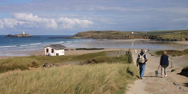 Walkers taking a dog towards Gwithian Towans Beach